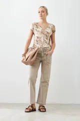 Blusa beige con estampado animal print, escote en V y mangas cortas.