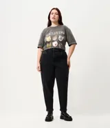 Pantalón de jean estilo mom, color negro, tiro alto, corte holgado en caderas y piernas, con bolsillos funcionales y cierre frontal.