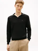 Chomba de manga larga Tommy Hilfiger de color negro, confeccionada en algodón orgánico con tejido de estructura estacional texturizada. Presenta cuello tipo chomba con cartera sin botones y el logo de la marca bordado discretamente en el pecho.