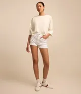 Short de mujer color blanco, tiro alto, confeccionado en sarga de algodón con un toque de elastano. Presenta un corte clásico con cierre frontal de botones.