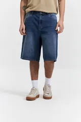 Bermuda de jean con corte baggy, de tiro medio y diseño amplio en piernas y cadera. Presenta un lavado azul clásico con efecto desgastado y cuenta con pasacintos.