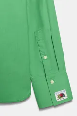 Camisa de popelín verde de manga larga con cuello solapa, cierre frontal de botones y dos bolsillos de parche en el pecho. Edición especial Fruit of the Loom x Zara.