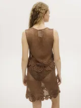 Falda corta de crochet confeccionada a mano en tejido calado, con apliques circulares tejidos en el ruedo y pretina elástica.