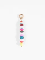 Llavero con argolla metálica dorada y una tira de cuentas de piedras de diversos colores y formas.