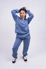 Pantalón de jogging color beige con cintura elástica y logo estampado en blanco en el muslo.