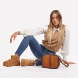 Cartera bandolera de cuero color marrón con detalles de costuras y logo de la marca en el frente.