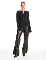 Blusa de punto negra con escote en V y detalle metálico en el pecho. Presenta mangas largas con puños decorados con apliques de strass y plumas negras.