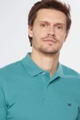 Remera polo de manga corta en tejido piqué color celeste. Presenta cuello clásico con botones, bordado pequeño en el pecho y detalles en tela oxford en el interior del cuello.