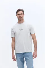 Remera de manga corta con cuello redondo y calce regular. Presenta un pequeño estampado minimalista en el centro del pecho.