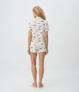 Pijama de viscolycra color beige con estampado de perritos marrones, compuesto por una camisa de manga corta con cuello solapa y botones frontales, y un short con cintura elástica.