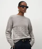 Suéter de punto color negro con cuello redondo y mangas largas. Presenta un diseño con franjas horizontales decoradas con lentejuelas del mismo tono en el cuerpo y las mangas.