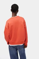 Buzo oversized de cuello redondo y manga larga, en color coral, con el texto 'L'AMOUR PARIS' bordado en el pecho en color blanco.