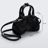 Cartera Melissa modelo Quantum Dome de material sintético brillante con acabado efecto charol, en color negro. Presenta un diseño estructurado de líneas curvas concéntricas, doble asa superior y correa ajustable y desmontable para llevar al hombro o cruzada. Cuenta con herrajes metálicos plateados.