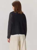 Saco abierto de punto con textura jaspeada en color gris oscuro, con bordes frontales en contraste color marrón. Presenta mangas largas y un corte recto.