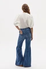 Jeans acampanados de tiro alto, color azul índigo lavado, con vuelo en el ruedo y confeccionados en denim de algodón con spandex.