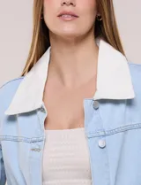 Campera de denim blanco de corte holgado con hombros caídos, cuello con solapa en contraste de color celeste, cierre frontal con botones metálicos y bolsillos delanteros con solapa.