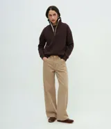 Pantalón de sarga color beige, de corte wide leg con cintura alta, cierre frontal con botón y cremallera, y bolsillos funcionales.