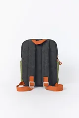 Mochila de pana con diseño de bloques de color. El cuerpo principal es gris oscuro con textura acanalada, un bolsillo frontal superior en verde oliva y un bolsillo frontal inferior en blanco crema con textura acanalada. Los tiradores de cremallera son de color cobre.