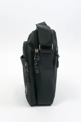 Morral de diseño compacto en color azul marino, con múltiples compartimentos con cierre, manija superior y correa ajustable para llevar al hombro. Incluye etiqueta con logo de la marca en la parte frontal.