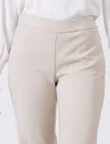Pantalón sastrero de corte slim, color blanco, con pretina anatómica y panel interno modelador. Presenta bolsillos laterales tipo ojal, bolsillos traseros simulados y nervadura vertical marcada en el frente.