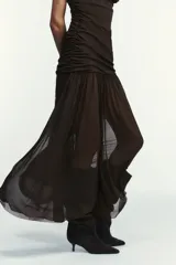 Vestido midi marrón con cuello alto y mangas cortas abullonadas. Presenta frunces en la parte superior y falda plisada. Incluye forro interior de tirantes finos ajustables y cierre lateral con cremallera oculta.