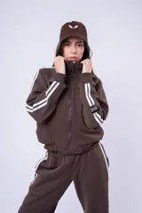 Campera tipo bomber color marrón, con cierre frontal completo, cuello alto y bandas laterales blancas en las mangas. Presenta puños y ruedo acanalados.