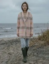 Cárdigan largo de tejido de punto con diseño a cuadros en tonos rosados y beige/gris. Presenta cuello chal y terminaciones con flecos largos en el borde frontal.