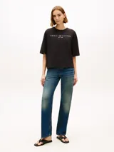 Remera negra de corte amplio de la marca Tommy Hilfiger, confeccionada en punto de puro algodón. Presenta cuello redondo, mangas cortas y anchas con hombros ligeramente caídos, y el logo de la marca estampado en el pecho en color blanco.