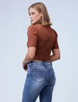 Top corto color verde militar, marca Tahari, confeccionado en símil gamuza. Tiene mangas cortas abullonadas, cuello redondo y cierre invisible en la espalda.