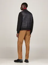Campera bomber negra con frente acolchado y mangas de tejido liso. Cuello, puños y bajo de punto canalé. Cierre frontal con cremallera. Logo de Tommy Hilfiger bordado en el pecho.