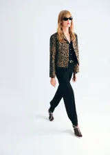 Chaqueta corta de corte recto con estampado de leopardo, cuello camisero, manga larga, bolsillos delanteros de parche y cierre frontal con botones.