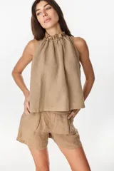 Blusa de lino italiano color marrón oscuro, con corte en línea A, hombros descubiertos, escote halter con frunces y volado en el cuello.