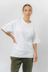 Remerón de algodón color blanco, con calce oversize, cuello redondo clásico, hombros caídos y mangas amplias. Presenta una textura sutil en la parte superior delantera.