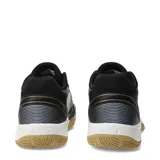 Championes de fútbol sala Umbro modelo Grip Pad, color negro con detalles en dorado y blanco. Presentan una suela de goma color caramelo diseñada para superficies de interior, con refuerzos en la puntera y laterales para mayor durabilidad.