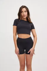 Calza corta negra ajustada al cuerpo, tiro medio, confeccionada en tejido suave con protección UV50+ y logo estampado al tono.