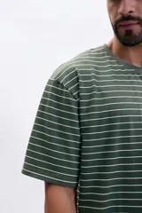 Remera de corte oversize con cuello redondo y mangas cortas, presenta un diseño de rayas horizontales finas en color verde y blanco.