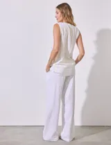 Blusa sin mangas de lino y rayón a rayas verticales amarillas y celestes, con cuello a la base y escote en V, abertura central con botones y terminación anudada.