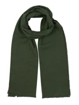 Bufanda unisex de textura suave en color verde oscuro, con bordes desflecados y una pequeña etiqueta de cuero sintético en uno de los extremos.
