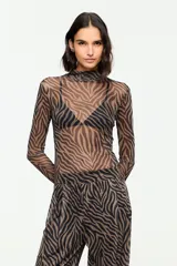 Blusa de tul semitransparente con estampado animal print tipo cebra en tonos marrón y negro, cuello alto y mangas largas.