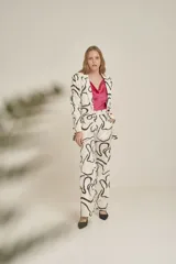 Pantalón de vestir color crudo con estampado abstracto en negro. Corte recto y tiro alto.