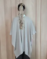 Ruana tejida en algodón con destellos de lurex, de corte amplio y diseño abierto, con textura en punto relieve.