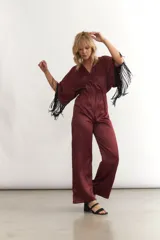 Mono largo de seda color celeste, con escote en V cruzado, mangas cortas amplias con flecos negros y cintura elastizada.