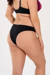 Bombacha de bikini negra con laterales de puntilla elastizada fucsia y detalle de abertura circular en el frente.