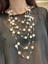 Collar de varias vueltas compuesto por cadenas finas doradas intercaladas con perlas de distintos tamaños. Cuenta con cierre de mosquetón y cadena de alargue.