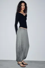 Pantalón de tiro medio con cintura elástica y bajo acabado en puño elástico. Presenta un diseño con tejido efecto arrugado y bolsillos laterales ocultos en costura.