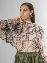 Camisa de seda italiana con diseño reversible, permitiendo usar el lazo en la parte frontal o posterior. Presenta un estampado sutil con motivos abstractos y animal print, cuello alto con volados, mangas largas con puños elásticos y corte holgado.