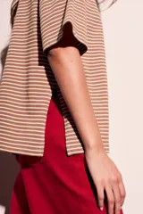 Remera marrón con rayas horizontales blancas, cuello redondo y mangas cortas.