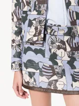 Minifalda confeccionada en jacquard multicolor con estampado abstracto, forrada en tafeta jacquard. Lleva cinto en tela base con dos broches dorados. Acceso mediante cierre invisible en lateral. Vivos en ruedo de cuero vacuno con efecto desgastado.