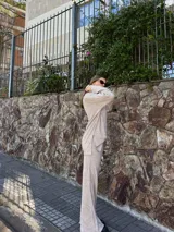 Conjunto de dos piezas de tejido texturizado color beige, compuesto por un buzo de manga larga con cuello polo y un pantalón de corte recto y holgado.