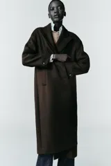 Abrigo largo de corte recto confeccionado en tejido con mezcla de lana, color marrón oscuro. Presenta cuello con solapas, cierre frontal con botones y bolsillos laterales de vivo.